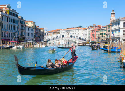 Venedig Italien Venedig Gondoliere Rudern eine Gondel voll von Touristen auf eine Gondelfahrt auf dem Canal Grande in der Nähe der Rialtobrücke Venedig Italien eu Europa Stockfoto