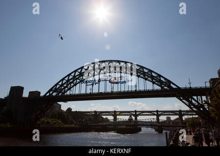 Ein Helikopter fliegt über den Tyne Bridge in Newcastle-upon-Tyne, England. Die Brücke überquert den Fluss Tyne zwischen Newcastle und Gateshead. Stockfoto