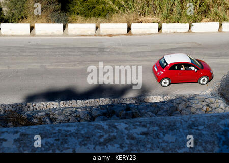 Ein Blick auf einen rot-weißen Fiat 500 Auf einer Straße gefahren zu werden und zu gehen Von Schuss nach rechts Stockfoto