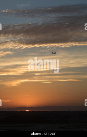 Chicago, Illinois - ein Verkehrsflugzeug, fährt vom Flughafen O'Hare International Airport entfernt, wie die Sonne. Stockfoto