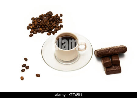 Körner von Kaffee, eine Tasse Kaffee und Pralinen auf weißem Hintergrund Stockfoto