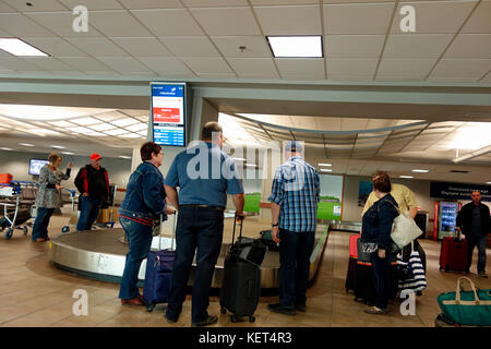 Die Menschen warten auf ihr Gepäck am Flughafen Karussell Gepäckausgabe Stockfoto