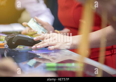 Asian Business Frauen hand mit Kreditkarte swiping Machine für die Zahlung in der Cafeteria und Supermarkt Stockfoto