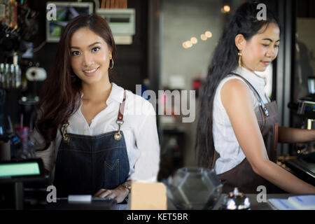 Asiatische Frauen barista lächelnd und mit Kaffeemaschine im Coffee Shop counter-Working Woman Small Business Owner Essen und Trinken cafe Konzept Stockfoto