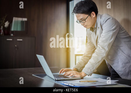 Asiatische Geschäftsleute mit Notebook und Unterlagen auf dem Tisch zum Arbeiten Stockfoto
