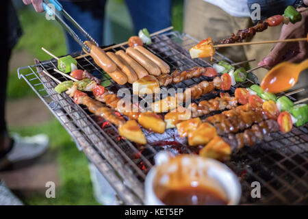 Asiatische Gruppe von Freunden, Grill und gegrillten shashliks auf das Gitter Party im Garten Stockfoto