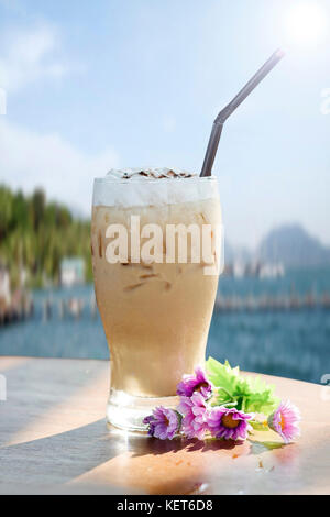 Eis Cappuccino auf einem Holztisch auf Meerblick Hintergrund Stockfoto