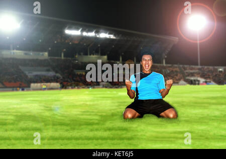 Fußball-Fußball-Spieler junger Mann glück Freude kniend und Fußball-Spieler team Gruppe feiert den Sieg und Meister des Spiels im Fußball Stadion Stockfoto