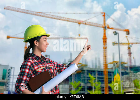 Frauen Asien Ingenieur arbeiten und halten Blaupausen auf Baustelle Stockfoto