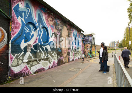 Die Leute bewundern und fotografieren einige erstaunliche Straße kunst, die Brick Lane in London, England Stockfoto