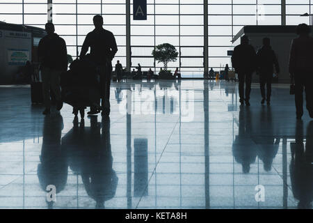 Shanghai, China - Dezember 6, 2014: die Passagiere sind in der wartehalle von Shanghai Pudong International Airport. Zurück beleuchteten Foto mit dunklen Silhouetten Stockfoto