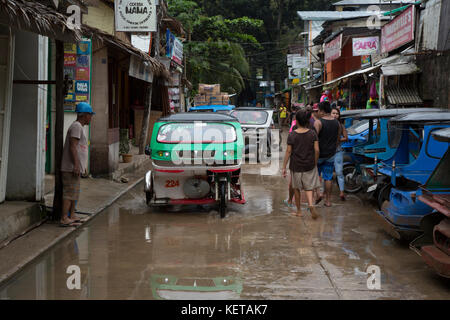 Motorisierte dreiräder (Auto-rikscha) bei nassen Straßen von El Nido, Palawan Stockfoto