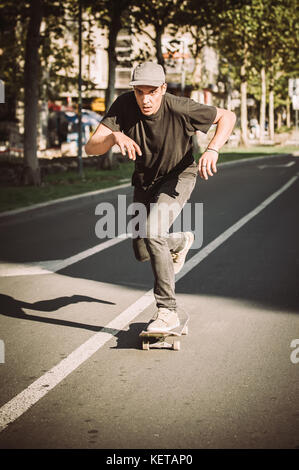 Pro Skate rider ride Skateboard vor dem Auto auf die Stadt Straße Straße durch Staus Stockfoto