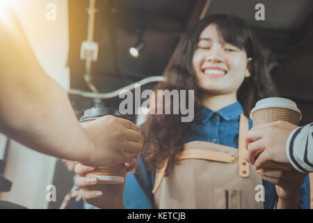 Asiatischer Barista, die Kunden in ihren Shop. Selektive konzentrieren. Cafe Restaurant Service, Essen und Trinken Industrie Konzept. Stockfoto