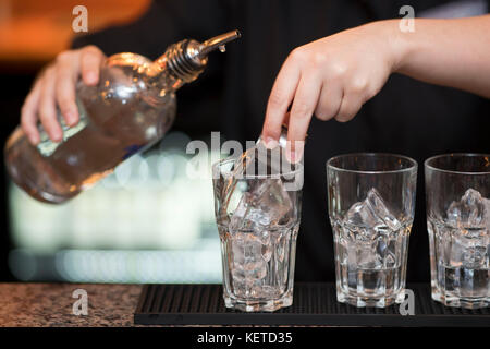 Ein Barkeeper/bar Arbeiter gießt Aufnahmen von Spirituosen in einer Bar Pub. Stockfoto