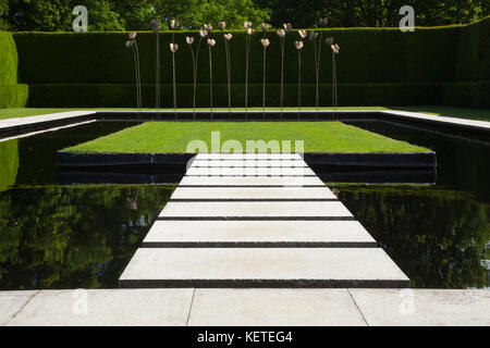 Die zeitgenössische Wasser Garten mit moderner Kunst Skulptur ist von hohen Eibe Hecken umschlossen, Gärten, Cotswolds Kiftsgate Court, Gloucestershire, England. Stockfoto