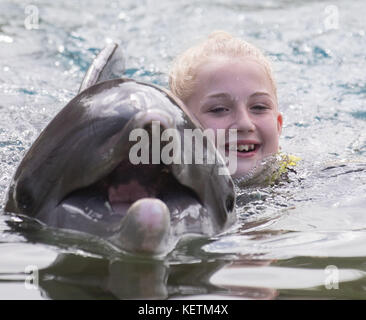 Jaz Ellis, 8, aus Poole, Dorset, schwimmt mit einem Delfin während des Traumflugs in Discovery Cove in Orlando, Florida. Stockfoto