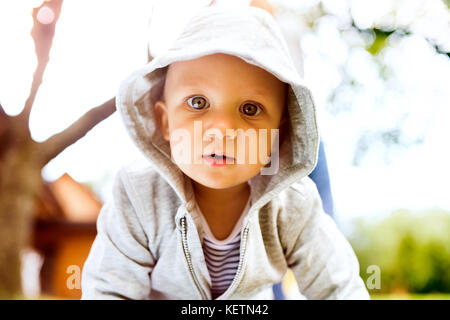 Baby auf dem Rasen im Garten. Stockfoto