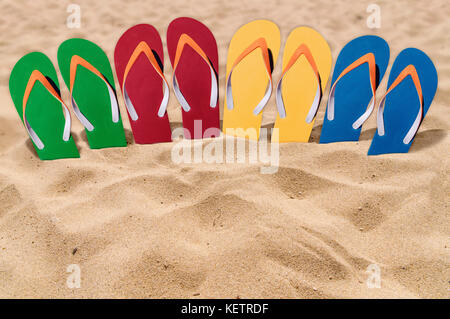 Mann Lebensstil vier Entspannen flip flops auf orange Sandstrand Stockfoto