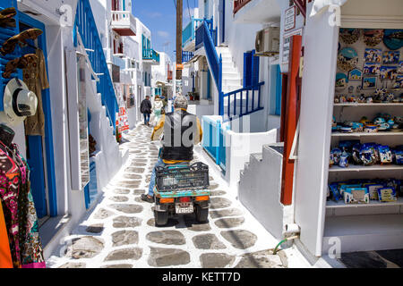 Lokale Mann auf Fracht dreirädriges Antriebe an einer engen Gasse, Mykonos Stadt, Mykonos, Griechenland Stockfoto