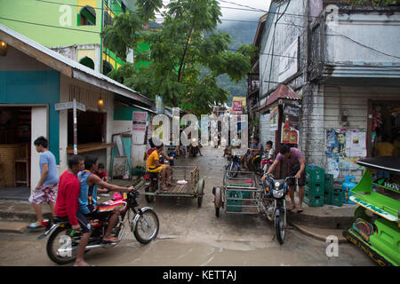 Motorisierte dreiräder (auto Rikscha) und Motorräder in nassen Straßen von El Nido, Palawan, Philippinen Stockfoto