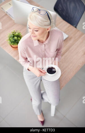 Smart Business Person mit Kaffee sitzen am Schreibtisch Stockfoto