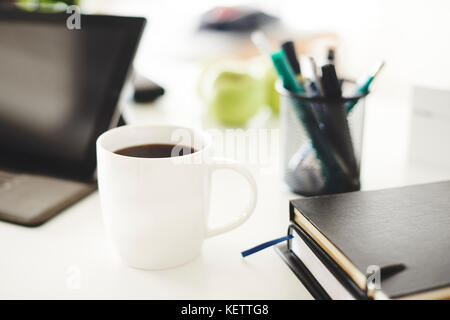 Schuß von Bürobedarf mit Becher Kaffee Stockfoto