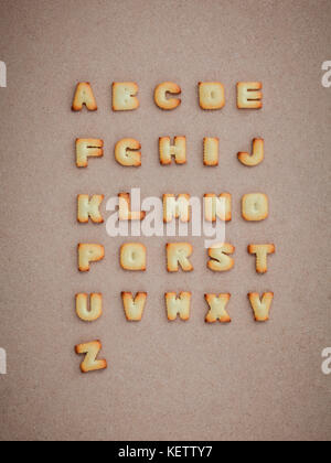 Cookies abc in Form von Alphabet a-z auf braunen Karton Hintergrund, Valentines Tag Stockfoto