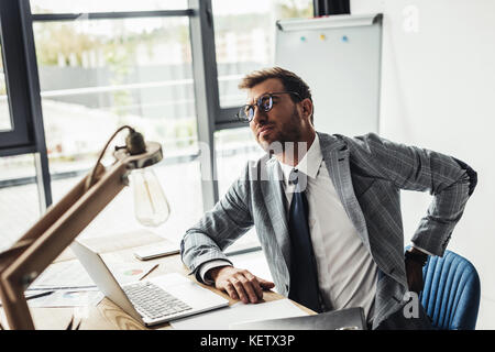 Geschäftsmann mit Rückenschmerzen Stockfoto