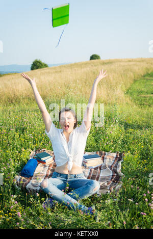 Freundliche hübsche Frauen ihr Buch werfen in die Luft Gefühl glücklich und frei im Freien Stockfoto