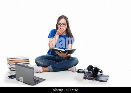 Schüler Mädchen sitzen Durchgebohrt und Gähnen wie mit Büchern und Kaffee rund um auf weißem Hintergrund die Müdigkeit Stockfoto