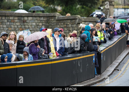 Windsor, Großbritannien. 23. Oktober, 2017. Touristen warten im Regen für den Wachwechsel Zeremonie im Schloss Windsor. Credit: Mark Kerrison/Alamy leben Nachrichten Stockfoto