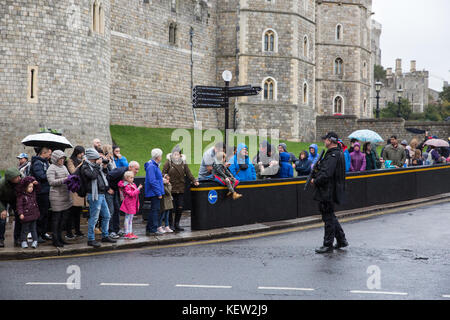 Windsor, Großbritannien. 23. Oktober, 2017. Touristen warten im Regen für den Wachwechsel Zeremonie im Schloss Windsor. Credit: Mark Kerrison/Alamy leben Nachrichten Stockfoto