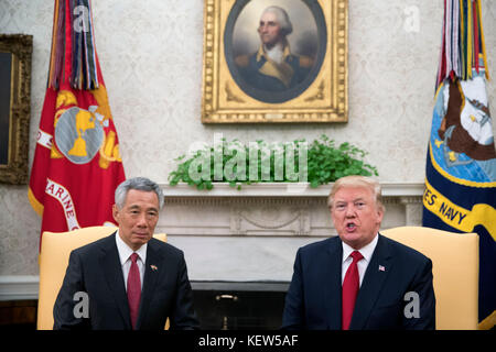 US-Präsident Donald Trump (R) begrüßt Premierminister Lee Hsien Loong (L) aus Singapur vor einer Reihe von Treffen zwischen den beiden im Weißen Haus in Washington, DC, USA, am 23. Oktober 2017 im Oval Office. Das Treffen findet weniger als zwei Wochen statt, bevor Präsident Trump eine längere Reise in den asiatisch-pazifischen Raum unternimmt. Gutschrift: Shawn Thew/Pool über CNP /MediaPunch Stockfoto