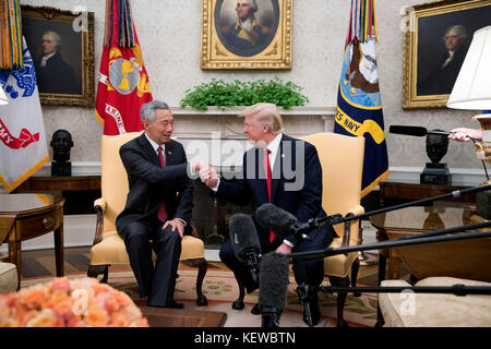 Washington, DC, USA. Oktober 2017. US-Präsident Donald Trump (R) begrüßt Premierminister Lee Hsien Loong (L) von Singapur im Oval Office vor einer Reihe von Treffen zwischen den beiden im Weißen Haus in Washington, DC, USA, am 23. Oktober 2017. Das Treffen findet weniger als zwei Wochen vor einer ausgedehnten Reise von Präsident Trump in den asiatisch-pazifischen Raum statt. Kredit: Shawn Thew/Pool über CNP - KEIN KABELSERVICE - Kredit: Shawn Thew/Consolidated/dpa/Alamy Live News Stockfoto