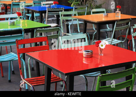 Farbenfrohe Tische und Stühle in einem Café im Freien in Placa Reial, Barcelona, Spanien. Stockfoto