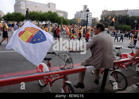 Barcelona, Spanien, 12. Oktober 2017. Eine pro Spanisch Einheit Demonstrant Wellen eine Fahne mit der katalanischen, spanischen und EU-Flaggen zusammen Stockfoto