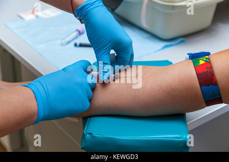 Der Arzt stellt das Blut aus der Vene am Arm Stockfoto