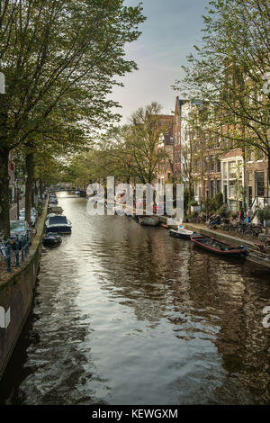 Herbst auf einer für Amsterdam typischen Kanal, angelegte Boote, Autos und Fahrräder. Stockfoto