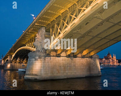 Horizontale Blick auf die Häuser des Parlaments unter der Margaretenbrücke in Budapest bei Nacht. Stockfoto