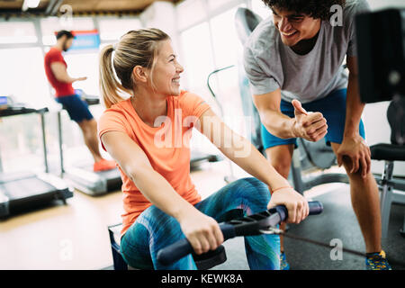 Junge schöne Frau Übungen mit Personal Trainer Stockfoto