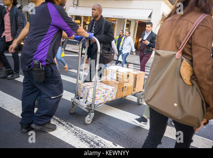 Ein fedex Mitarbeiter in New York in einer geschäftigen Zebrastreifen, die Pakete ausliefern, am Donnerstag, den 19. Oktober 2017. (© Richard b. Levine) Stockfoto