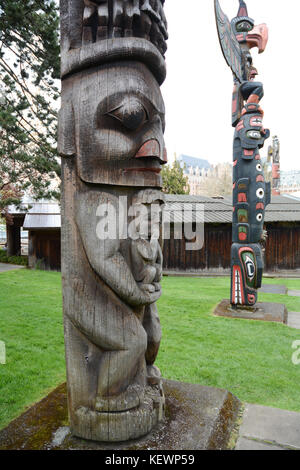 Traditionelle Nordwesten indigenen Totempfähle auf Anzeige auf dem Gelände des Royal BC Museum, Victoria, British Columbia, Kanada. Stockfoto