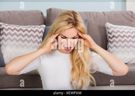 Porträt einer jungen Frau mit Kopfschmerzen zu Hause Stockfoto