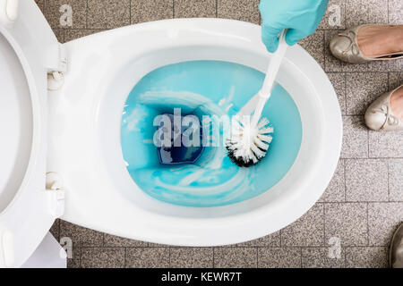 Hohe Betrachtungswinkel und einer Person reinigt ein Badezimmer WC mit einer Scheuerbürste Stockfoto