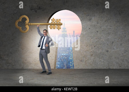 Geschäftsmann mit Schlüssel und Puzzle Stücke Stockfoto