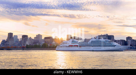 Boot segeln bei Sonnenuntergang auf St. Lawrence River mit Skyline im Hintergrund. Stockfoto