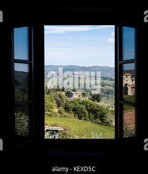 Blick durch ein Fenster der Ferienwohnung in der Toskana zu den Hügeln mit Weinbergen in Castellina in Chianti in Italien Stockfoto