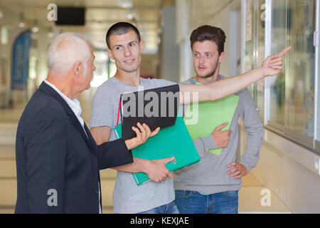 Student an eine Ankündigung auf dem Board zeigen Stockfoto