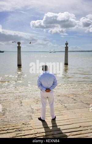 Einsamer Mann vor dem Tejo. Cais das Colunas, Lissabon, Portugal Stockfoto